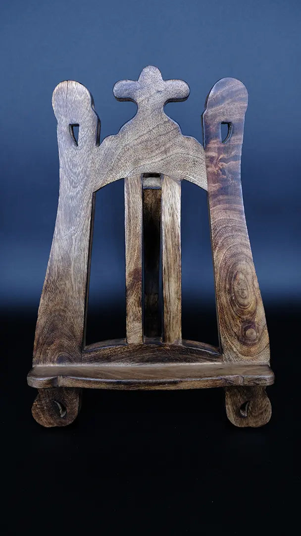 A wooden fantasy bookstand over a black background, front view