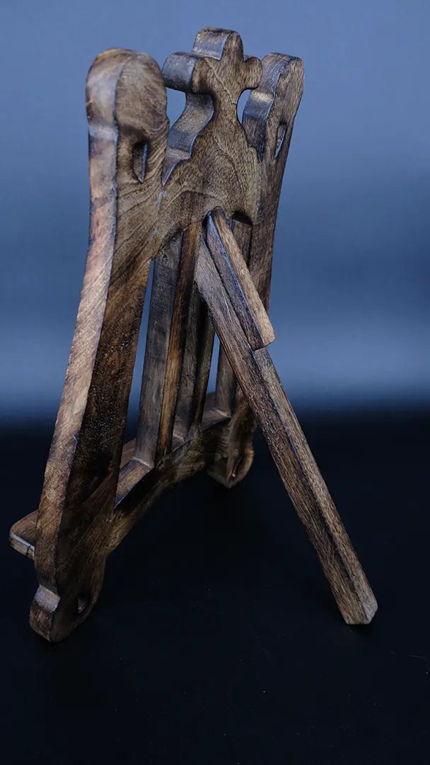 A wooden fantasy bookstand over a black background, lateral view