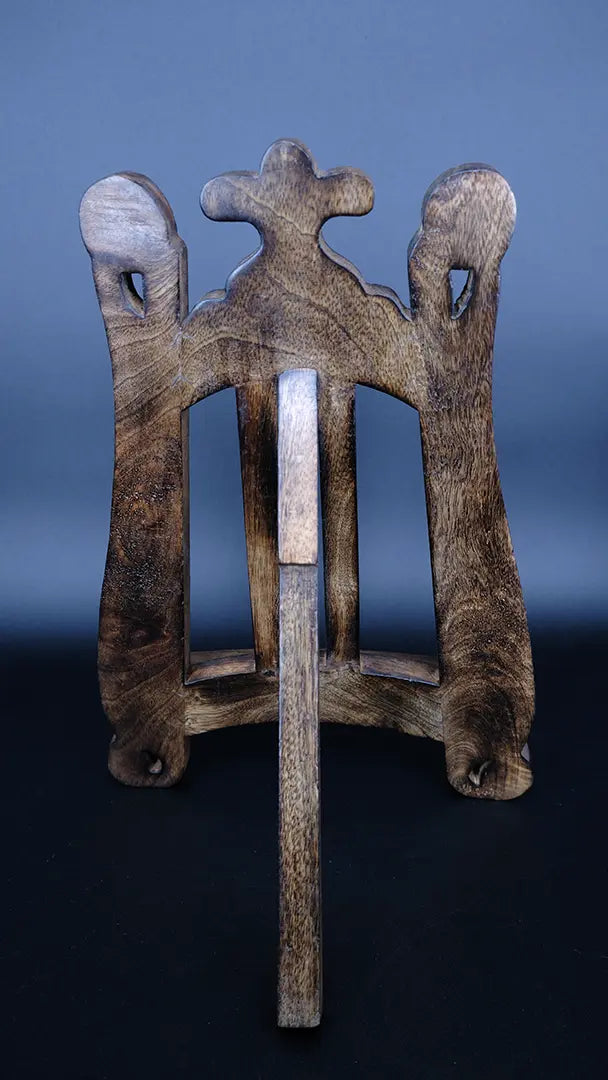 A wooden fantasy bookstand over a black background, rear view