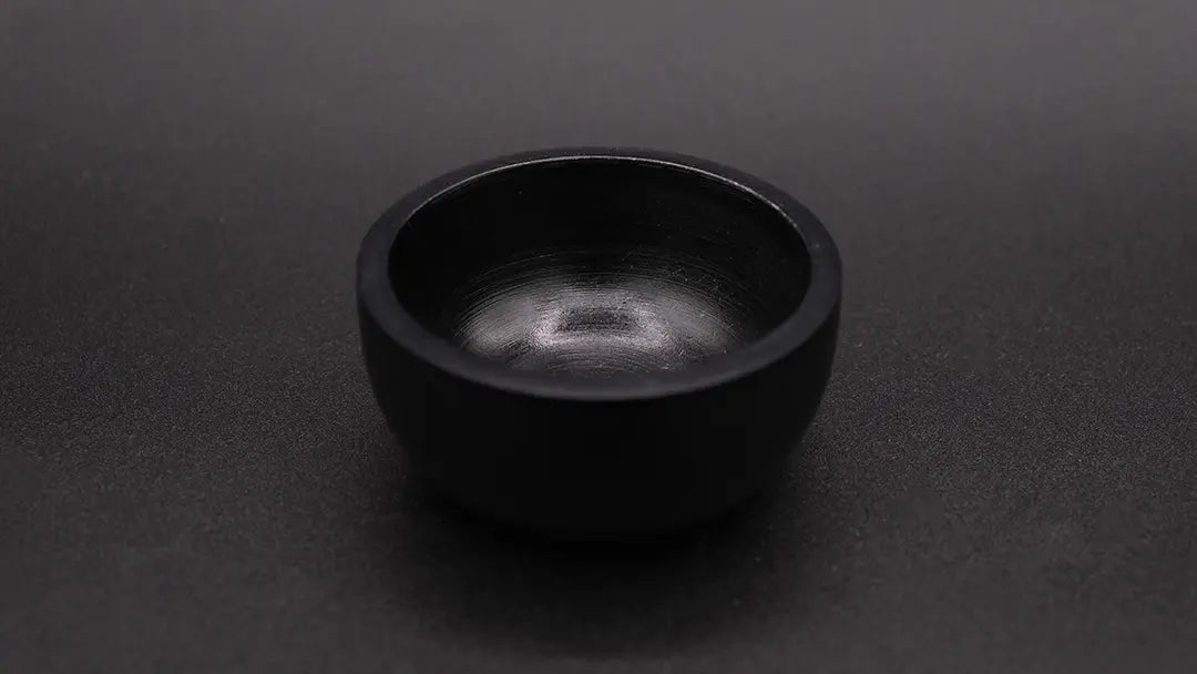 Black cup in steatite placed over a black background
