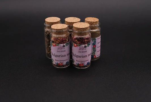 Set of 5 bottles of bulgarian rose incense placed over a black background