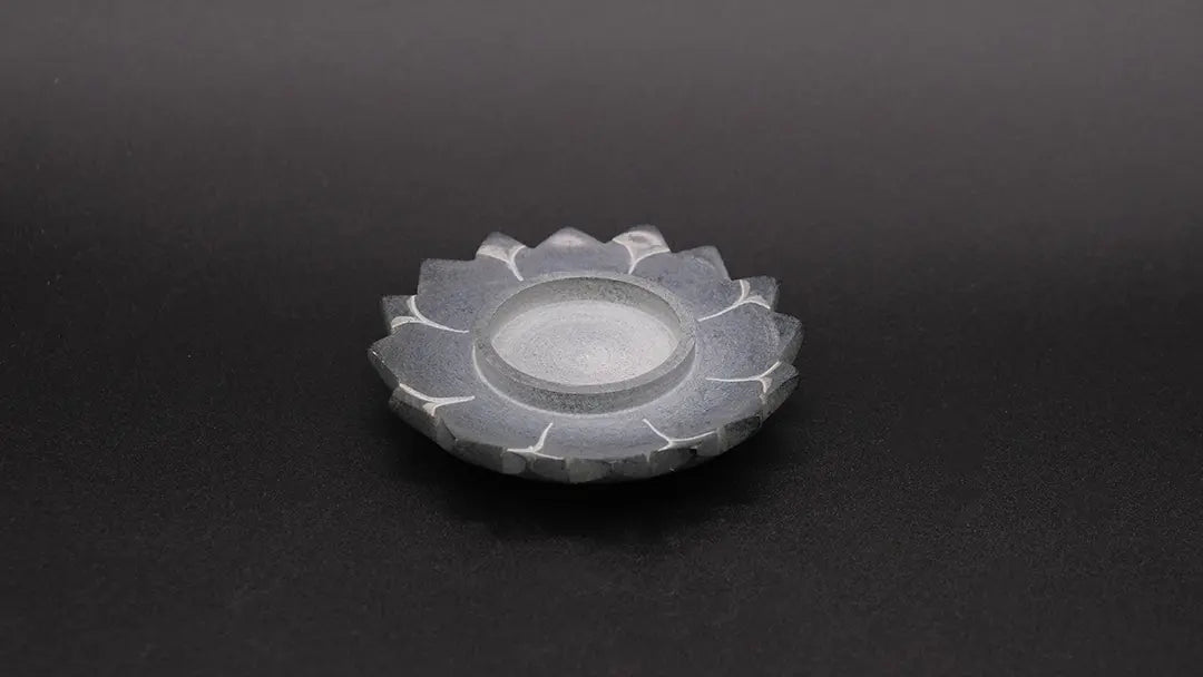 Steatite Lotus Candle Holder on the black background.