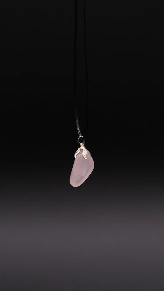 Rose Quartz Pendant over black background.