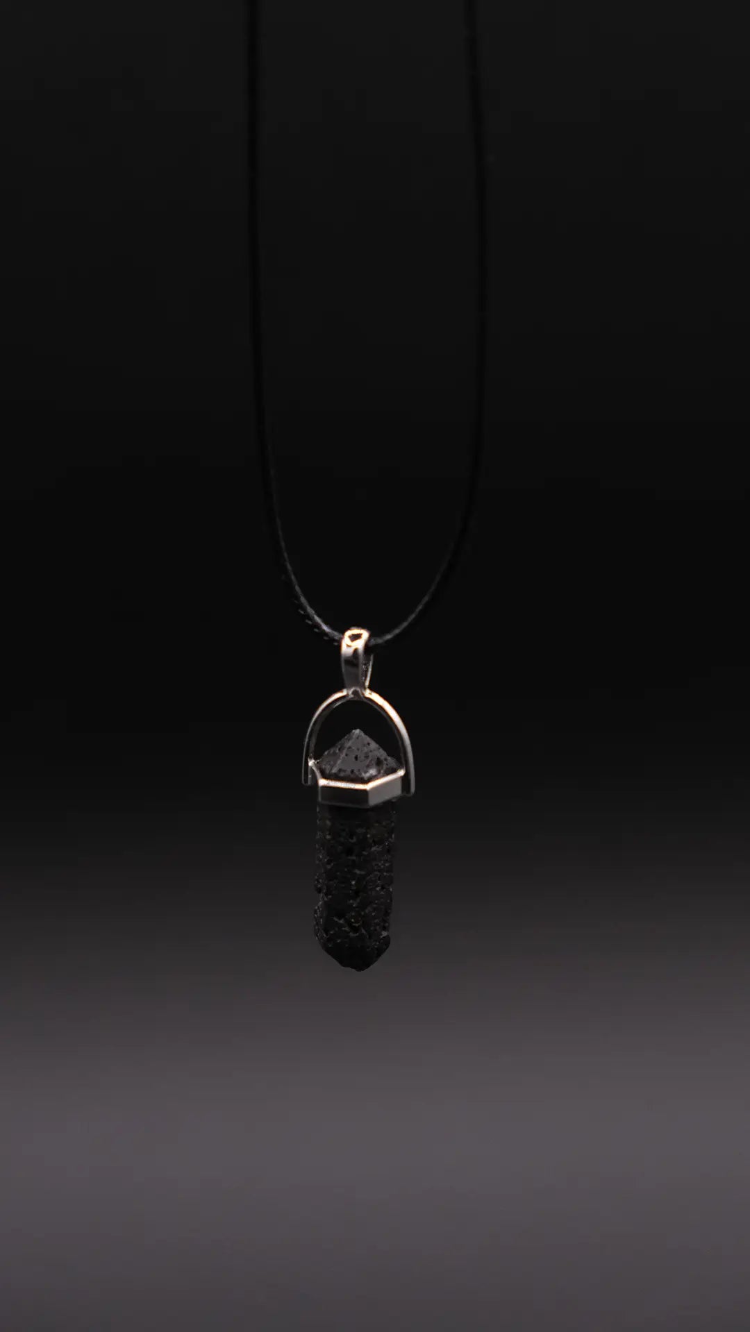 Prism Pendant made from Lava Stone on the black background.