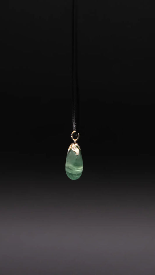 A green aventurine pendant over a black background