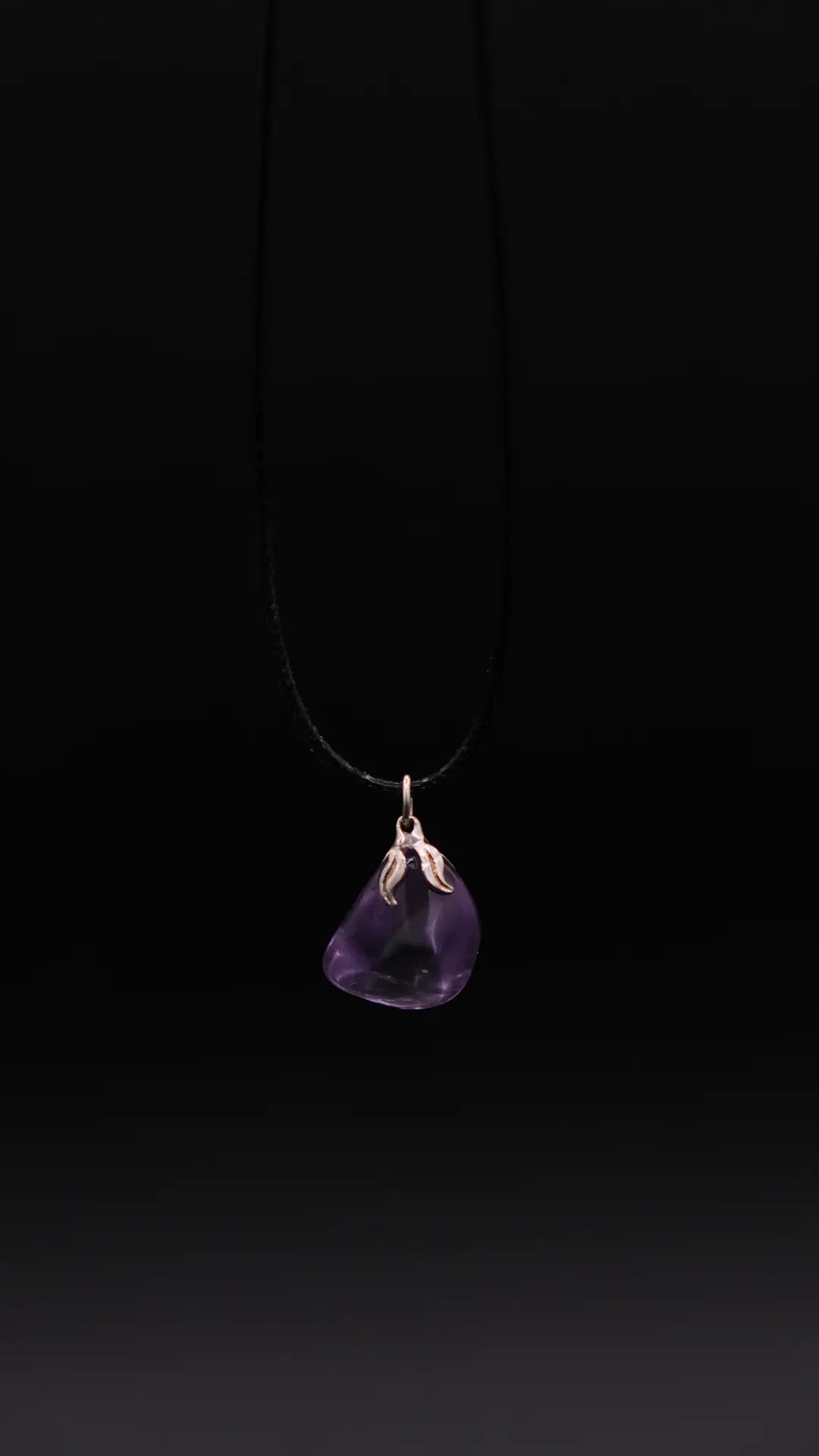 pendant in amethyst over a black background