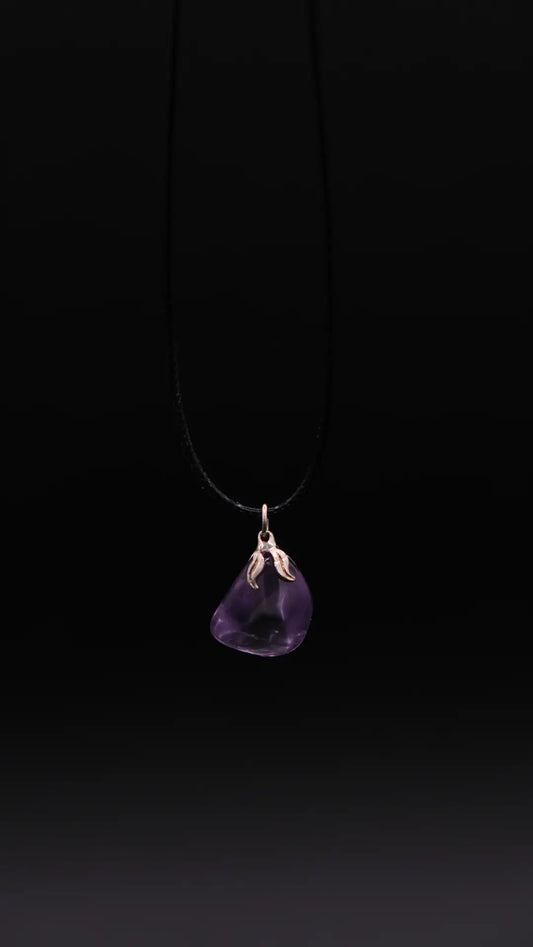 pendant in amethyst over a black background