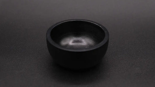 Black cup in steatite placed over a black background