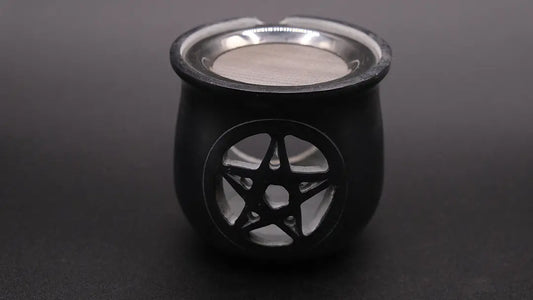 Black incense burner in steatite with a pentacle over a black background, front view