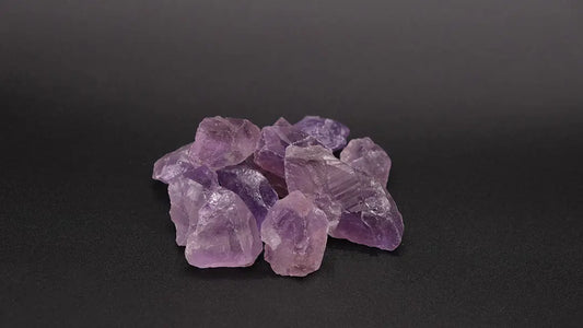 A composition from raw amethyst pack over the black background.