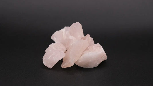 A composition of  raw rose quartz on the black background.