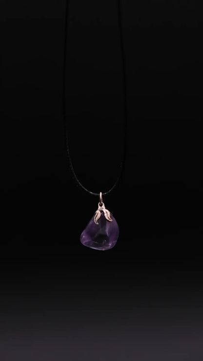 pendant in amethyst over a black background