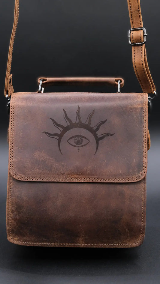 A Shoulder bag in light brown leather with solar crown symbol engraved on the black background.