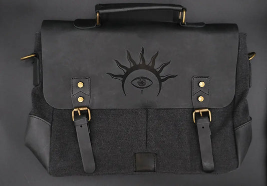A black leather satchel engraved with a mystic eye with a solar crown. Dark academia style